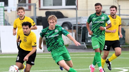 Arzheims Rafael Gräper (am Ball) im Duell mit Engers II-Spieler Paul Herschbach (grünes Trikot, Mitte).