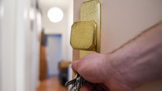 Ein Mann schließt eine Wohnungstür auf und öffnet sie. Doch vielerorts gibt es zu wenig Wohnraum, auch in Lahnstein.