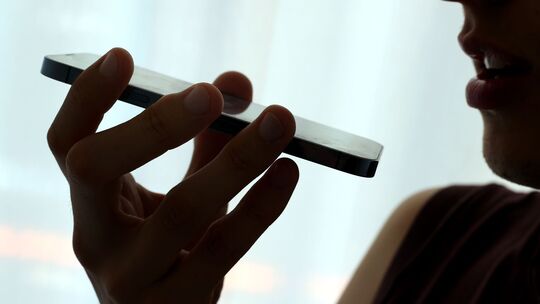 Mann spricht eine Sprachnachricht in sein Smartphone