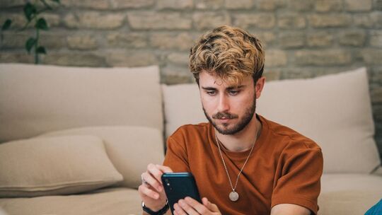 Ein junger Mann bedient sein Smartphone