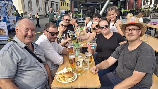 Eine Gruppe aus Stromberg genießt den Tag bei leckerem Essen und einem frisch gezapften Bier.