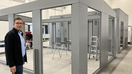 Stephan Bilo steht vor der Außenhülle für eine Trafostation in der Größe eines zweistöckigen Häuschens – mit eine der größten An