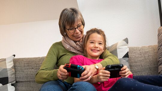 Eine Oma und ihre Enkelin spielen zusammen Videospiele Eine Oma und ihre Enkelin spielen zusammen Videospiele