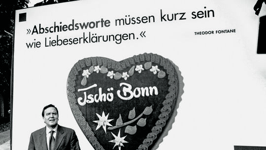 Der damalige Bundeskanzler Gerhard Schröder (SPD) verabschiedet sich im Jahr 1999 mit einem Plakat von der Bundeshauptstadt Bonn Der damalige Bundeskanzler Gerhard Schröder (SPD) verabschiedet sich im Jahr 1999 mit einem Plakat von der Bundeshauptstadt Bonn