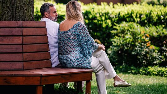 Ein Mann und eine Frau sitzen auf einer Bank Ein Mann und eine Frau sitzen auf einer Bank