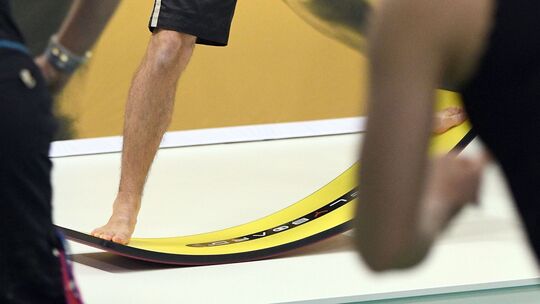 Mann steht auf einem Balance Board Mann steht auf einem Balance Board