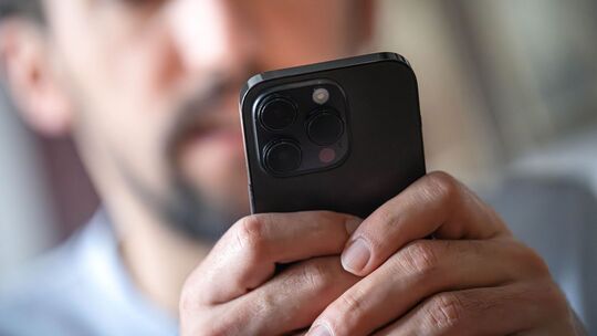 Ein Mann tippt auf einem Smartphone Ein Mann tippt auf einem Smartphone