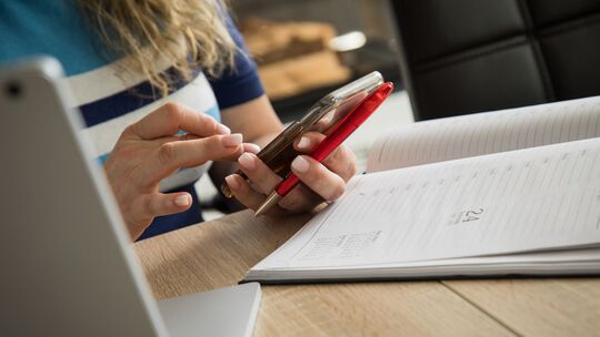 Eine Frau mit Handy, Laptop und Kalender Eine Frau mit Handy, Laptop und Kalender