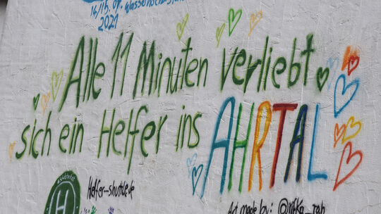 „Alle 11 Minuten verliebt sich ein Helfer ins Ahrtal“ stand auf einer Hausfassade in Dernau. Welche Folgen ihr Einsatz für die H