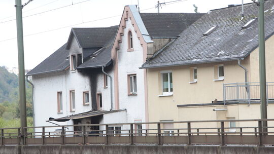 Ein dunkler Streifen an der Hauswand zeigt, wo am Abend zuvor der Brand war.