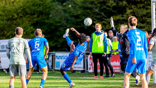 Ein super Tor: Dylan Esmel (in Blau) trifft in der 52. Minute artistisch zum 2:0-Endstand für den FC Emmelshausen-Karbach im Hei Ein super Tor: Dylan Esmel (in Blau) trifft in der 52. Minute artistisch zum 2:0-Endstand für den FC Emmelshausen-Karbach im Hei
