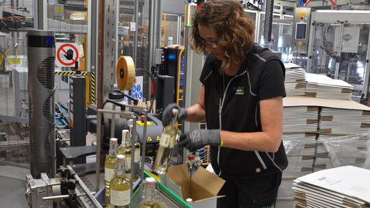 Die Flaschen mit dem frischen Destillat des Alten Apfel werden verpackt.