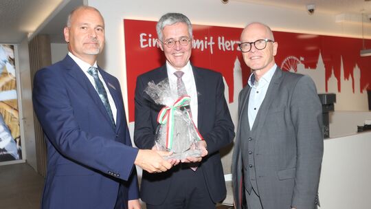 Einen kleinen Mühlstein überreichte Oberbürgermeister Dirk Meid an Karl-Josef Esch und den Filialleiter Thomas Theisen.