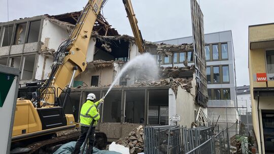Mit dem Einsatz großer Maschinen geht der Abriss des alten Wissener Rathauses zügig voran. Um die Staubbildung möglichst gering