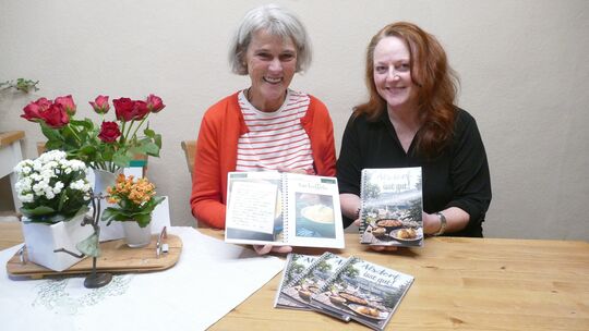 Sabine Solbach-Ruppelt und Christine Connely stellen das erste Alsdorfer Kochbuch „Alsdorf isst gut“ vor. Ein zweiter Band ist s