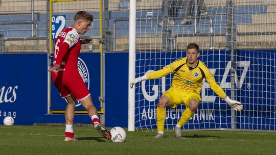 Die Entscheidung: Leon Pursian (in Rot) lupft den Ball zum 4:1-Endstand aus Sicht seiner Sportfreunde Siegen über Lottes Schluss
