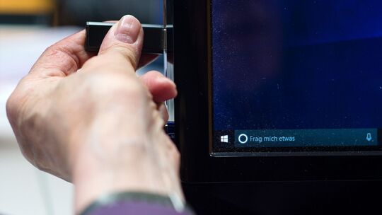 Eine Person zieht einen USB-Stick vom PC ab