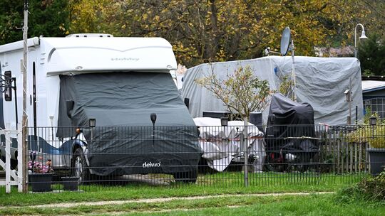 Ein Wohnmobil und ein Wohnwagen stehen auf einem Campingplatz Ein Wohnmobil und ein Wohnwagen stehen auf einem Campingplatz