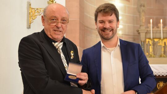 Andreas Leitzbach, Sprecher des Kirchenchors (links), durfte zum 100. Geburtstag des Kirchenchores aus der Hand von Jan-Martin C