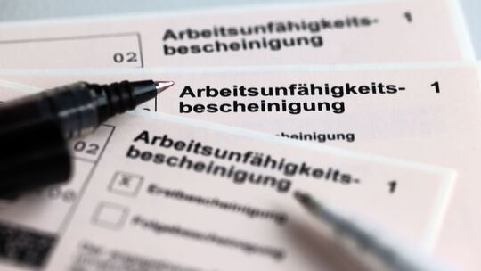 Arbeitsunfähigkeitsbescheinigungen liegen auf einem Tisch Arbeitsunfähigkeitsbescheinigungen liegen auf einem Tisch