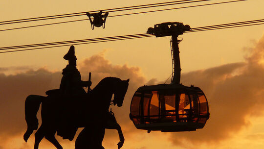 Das Denkmal Kaiser Wilhelms I. und im Vordergrund die Seilbahn in einem warmen Farbton eines Sonnenuntergangs.